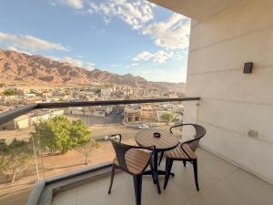 亚喀巴Coral Beach Hotel & Spa的阳台上有一张桌子和两把椅子，可以欣赏美景