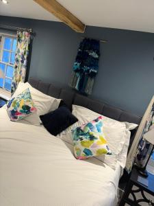 a bed with pillows on it in a bedroom at The Ship Inn's Mill Cottage - Weavers Way in Gatehouse of Fleet