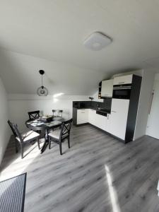 a kitchen and dining room with a table and chairs at Le Pigeonnier in Dombresson