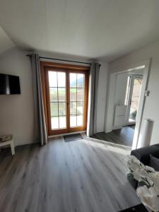 an empty living room with a sliding glass door at Le Pigeonnier in Dombresson
