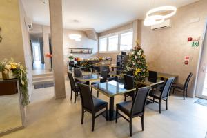 a restaurant with tables and chairs and a christmas tree at Hotel Richard in Agliana
