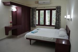 En eller flere senge i et værelse på Dew Drops Inn kovalam