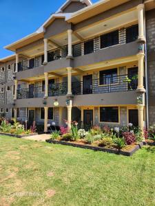 埃尔多雷特Queens Premier Suites in Eldoret Opposite Tamasha Village的公寓大楼前方有鲜花