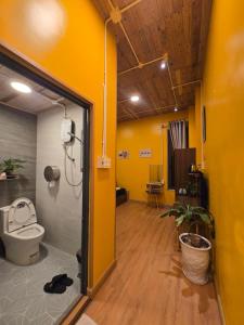 a bathroom with a toilet in a room with yellow walls at Lightning House 2 in Da Lat