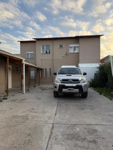 a car parked in front of a house at HOTEL Y RESTAURANTE CAñADON LEON in Gobernador Gregores