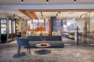 a living room with a couch and a table and chairs at B&B HOTEL Sassari in Sassari