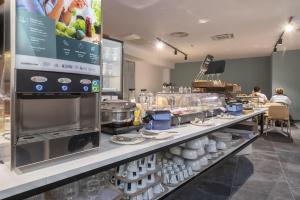 a kitchen with a counter with dishes on display at B&B HOTEL Sassari in Sassari