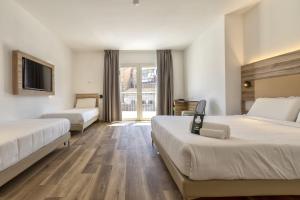 a hotel room with two beds and a tv at B&B HOTEL Sassari in Sassari +36 photos