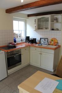 a kitchen with white cabinets and a stove top oven at FeWo Direkt Am See - Malchow in Malchow