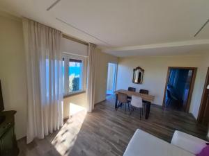 a living room with a table and a window at Madonna Dell'Aiuto True View Olivo in Brenzone sul Garda