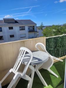 two white chairs and a table on a balcony at Spacieux T5 confort 9 pers in Angers