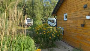 a house with a bunch of flowers next to a building at Kemping przy Suntago in Lublinów