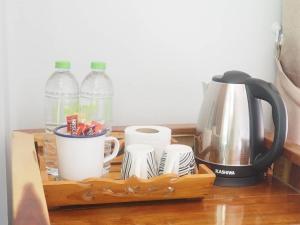 a wooden tray with cups and water bottles on a table at Mookies Bungalows in Ko Mook