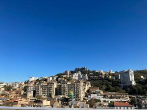 a view of a city with buildings on a hill at Hôtel Mon Royaume in Skikda