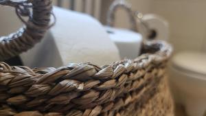 a wicker basket sitting next to a toilet in a bathroom at Madonna Dell'Aiuto True View Olivo in Brenzone sul Garda