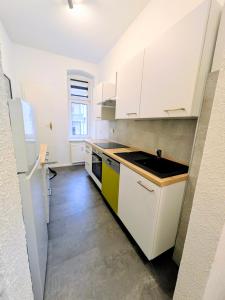 eine Küche mit weißen Schränken und einer Spüle in der Unterkunft AltstadtQuartier Bautzen in Bautzen