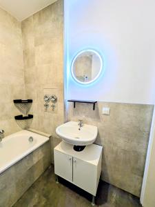 a bathroom with a sink and a tub and a mirror at AltstadtQuartier Bautzen in Bautzen