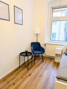 Zimmer mit einem blauen Stuhl und einem Tisch in der Unterkunft AltstadtQuartier Bautzen in Bautzen