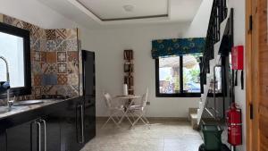 a kitchen with a sink and a table with chairs at Cuckoo's Nest in Tanji