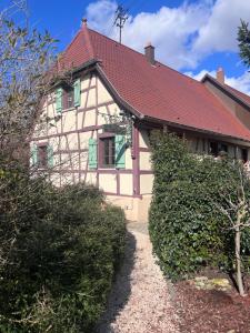 a house with a red roof and green shutters at Cocooning alsacien in Ottmarsheim