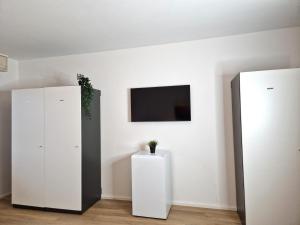 een kamer met twee witte kasten en een tv aan de muur bij Meribu D99 Wohnung für Monteure und Arbeiter in Gelsenkirchen