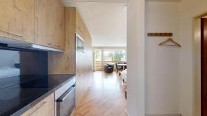 eine Küche mit schwarzen Arbeitsplatten und Holzschränken in der Unterkunft Gemütliche Studios in Davos - Bergblick & zentrale Lage in Davos