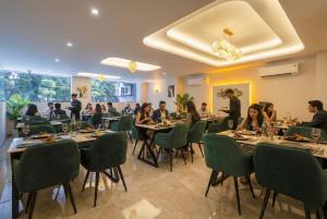 eine Gruppe von Menschen, die an Tischen in einem Restaurant sitzen in der Unterkunft Leaf 9 Grand, Near Udyog vihar and Yashobhoomi in Gurgaon + 112 Fotos