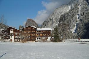 a lodge in the mountains with snow in the foreground at Gasthaus Rathaus in Safien Platz