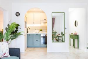 a kitchen with blue cabinets and a table with a chair at New! Sea View Apartment with Aircon in Center of Las Americas in Playa de las Americas