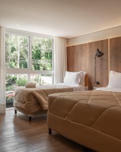 グラマドにあるHarmont Hotelのベッドが2つと大きな窓がある寝室