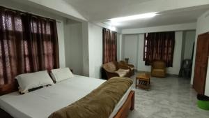 a bedroom with a large white bed in a room at Dzükou Guest House in Kohīma +7 photos