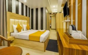 ニューデリーにあるGrow The Modesty Hotel# New Delhi # Mahipalpur # Family Hotel # Liftのベッドとテレビのある寝室