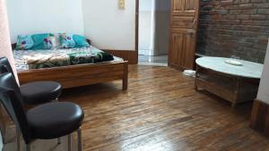una habitación con una cama, una mesa y sillas en Dzükou Guest House, en Kohīma