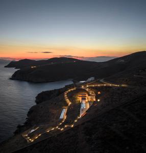an aerial view of a building on a hill with the ocean at Olen Syros in Megas Yialos-Nites