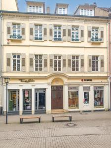ein großes Gebäude mit zwei Bänken davor in der Unterkunft Charmante, ruhige Wohnung im Herzen der Altstadt von Heidelberg in Heidelberg
