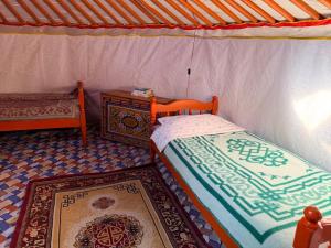 OngonNomadic home stay的一间卧室配有一张床、一张桌子和地毯