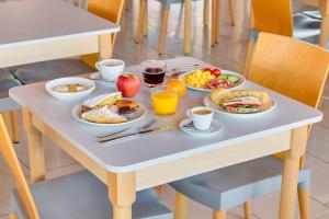 米兰B&B HOTEL Milano La Spezia的桌子上摆满了早餐食物