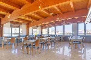 米兰B&B HOTEL Milano La Spezia的餐厅里有桌椅和窗户。