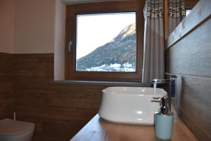 Un baño con lavabo y ventana. en Les Flocons Pila, en Pila