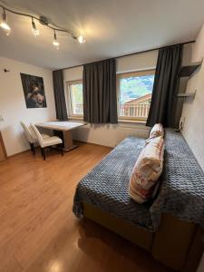 a bedroom with a bed and a desk in it at Ferienwohnung Eberharter Theresia in Ramsau im Zillertal