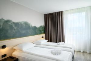 リュブリャナにあるB&B Hotel Ljubljana Parkの窓付きのホテルの部屋にベッドが2つある