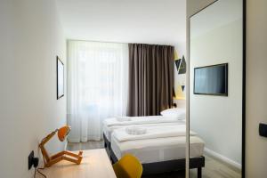 ein Hotelzimmer mit zwei Betten und einem Spiegel in der Unterkunft B&B Hotel Ljubljana Park in Ljubljana