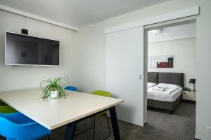 ein Zimmer mit einem Tisch und Stühlen und einem Bett in der Unterkunft B&B Hotel Ljubljana Park in Ljubljana + 11 Fotos