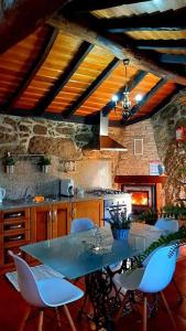 una cucina con tavolo, sedie e fornelli di Casa do Charco Peneda Gerês a Parada