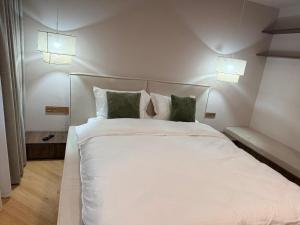 a bedroom with a white bed with green pillows at Vega House Luxury & Relax in Orşova +37 photos