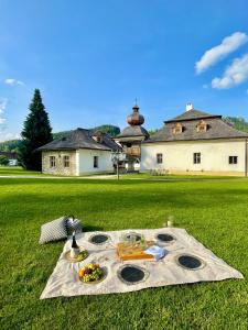 a table with food on a blanket on a field at Kaštieľ Kubínyi in Dolný Kubín