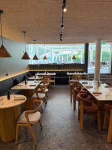 ein Restaurant mit Tischen und Stühlen und Fenstern in der Unterkunft Hotel Andante Rust in Rust