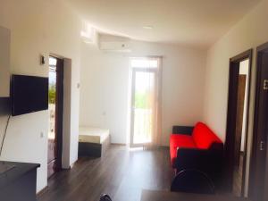 a living room with a red couch and a bed at BSG Rustaveli 184 in Kobuleti