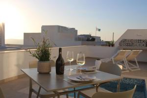 梅利哈8 North Lodge By Petit Chic的桌子上有一瓶酒和两个酒杯