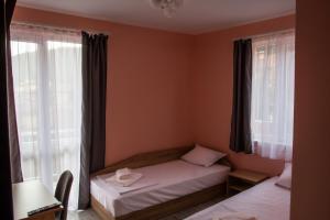 ein kleines Schlafzimmer mit zwei Betten und einem Fenster in der Unterkunft Dzhorgovata Guesthouse in Govedartsi